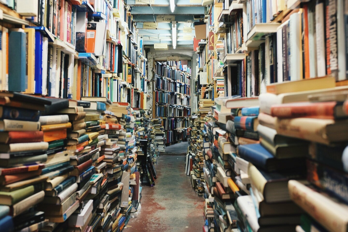 A library aisle between bookshelves full of books