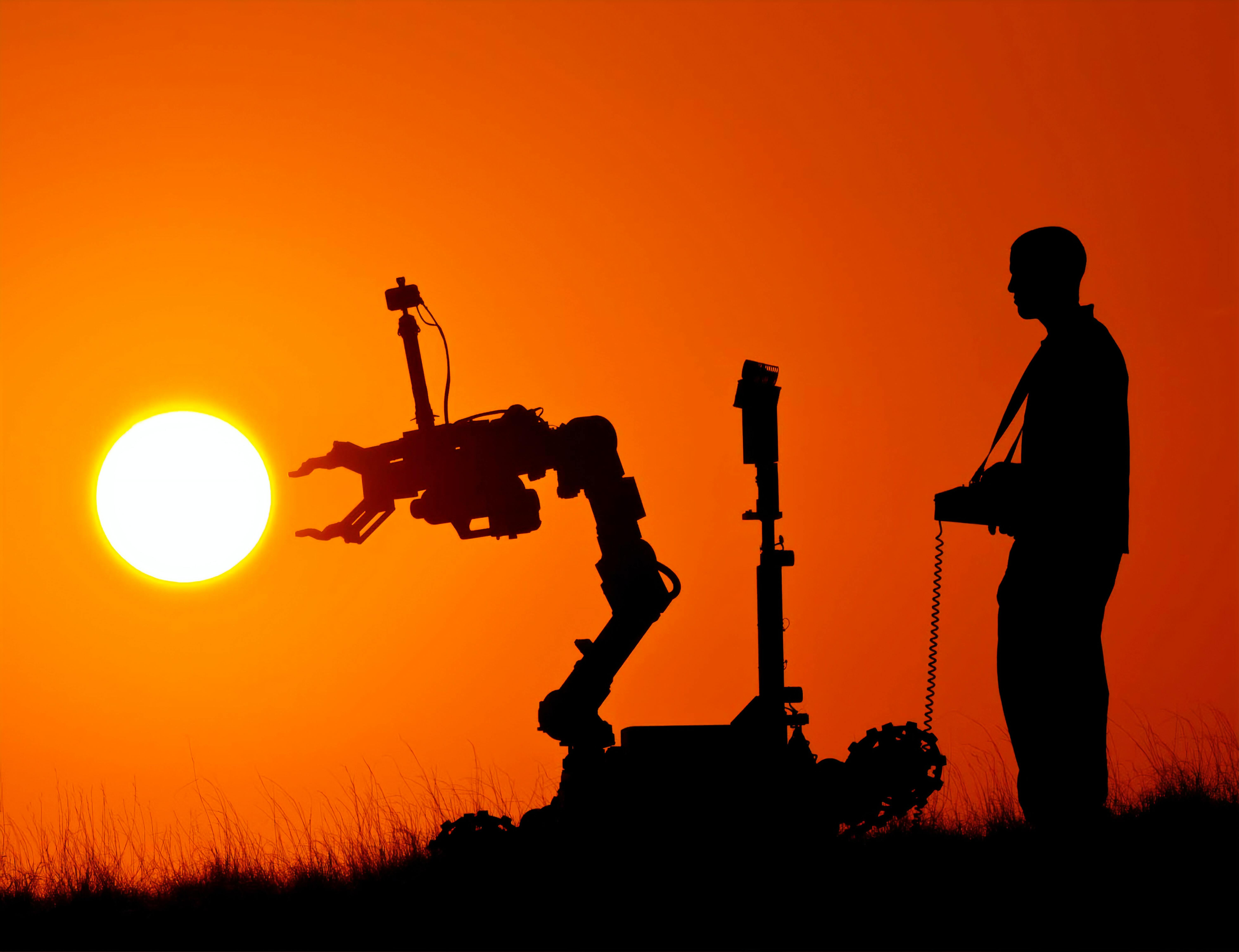 Person controlling a camera with a robot with a sunset in the background